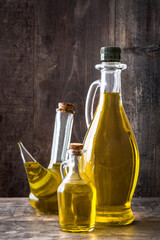 Virgin olive oil in a glass bottle on wooden background.