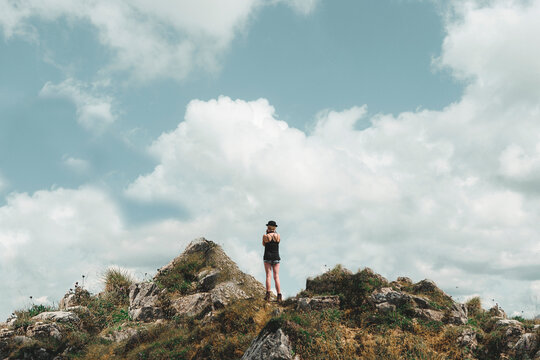 Young Woman standing on top of a mountain