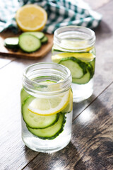 Detox water with cucumber and lemon on wooden table
