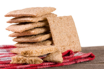 stack of crisp bread on a wooden table isolated white background