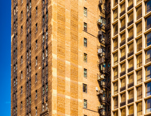 Block of flats in Chicago, apartment building in downtown against the blue sky, house made of brown bricks