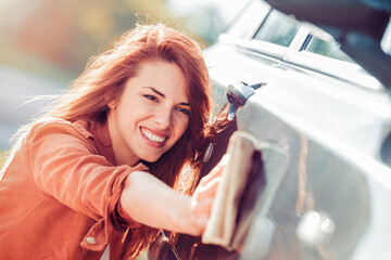 Fototapeta na wymiar Young woman cleaning her car outdoors