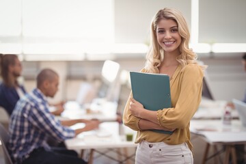 Portrait of smiling businesswoman holding file