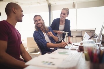 Happy business colleagues working together at creative office