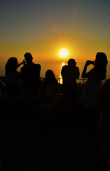 Fototapeta na wymiar Tourists photographing sunset