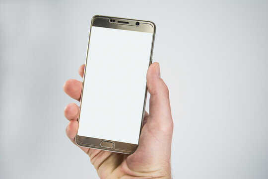 Close-up of a hand holding a phone. Modern smartphone. Isolated on white background. Showing the front of the phone. Blank screen for mockup.