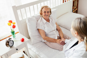 Providing care for elderly. Doctor visiting elderly patient at home.