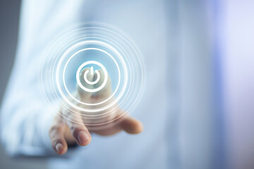 Businessman on blurred background holding render power button with his hand