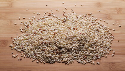 Integral, brown rice pile isolated on wooden table