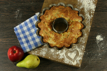 Homemade apple pie with a knitted cloth on wooden table