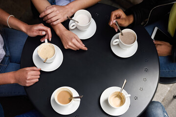 Top view of hands with coffee cups in a urban cafe.