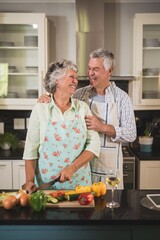 Happy senior couple standing together in kitchen