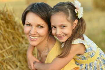 Mother with daughter on wheat field 