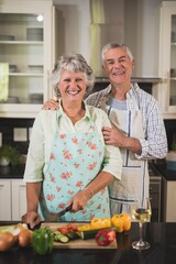 Portrait of happy senior couple standing in kitchen
