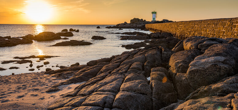 Rocky coast and lighthouse in Trevignonat sunset, Brittany