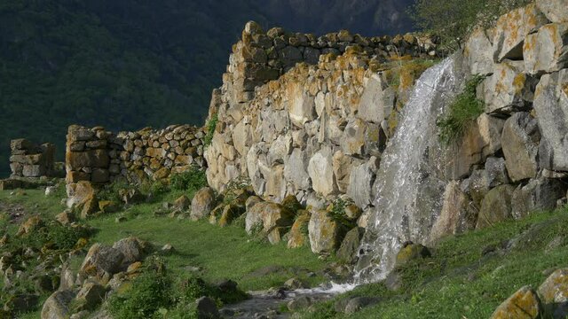 Water flows from ruined ancient wall