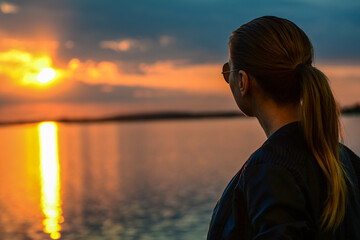 A female blonde watching the sunset at Lake Morii, Bucharest, Romania