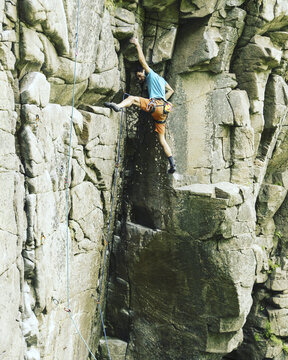 A young man climbs in a canyon.