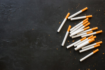 Cigarettes and tobacco on a black background with space for text