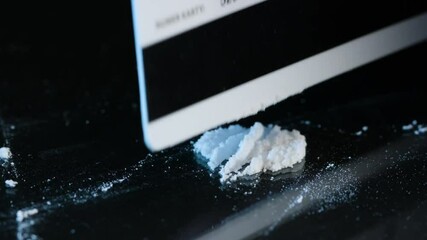 Drug Abuse. Forming two lines of drug powder with a plastic card. Problems with drugs concept. Black background. Close-up macro shot. - Powered by Adobe