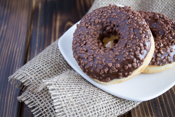 Chocolate donuts on a rustic wooden background