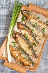 
Roasted fish. Roasted river fish roach on an old brown wooden tray.