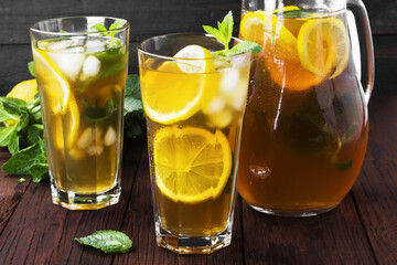 Ice tea with lemon and mint on a wooden background