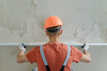 Worker is putting a gypsum plaste.