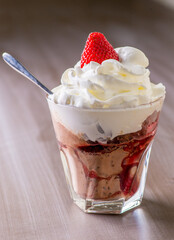 Ice cream with topping and berries in a glass