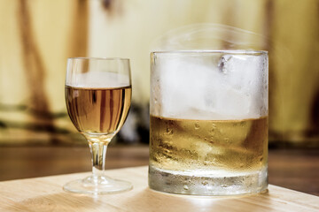 Whiskey shot glass & full tumbler with smoke & ice