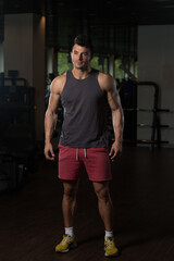Naklejka na ściany i meble Fitness Model In Undershirt Flexing Muscles