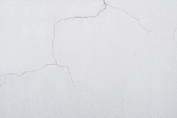 On the wall a lot cracks on a beige plaster