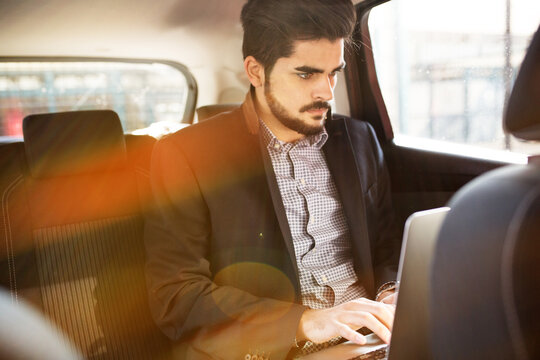 Attractive Businessman Using Laptop In The Car.