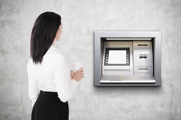 Rear view of woman with coffee, atm machine