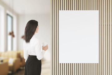 Woman with coffee looking at poster