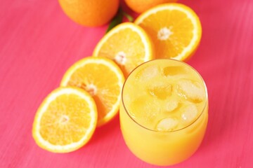 Fresh orange juice on pink background  