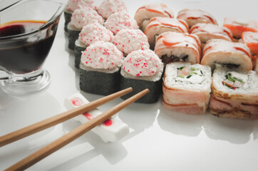 Sushi set with soy and sticks on white background