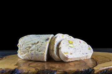 Fiambre casero de pollo jamón bacon y pistachos loncheado sobre una tabla de corte