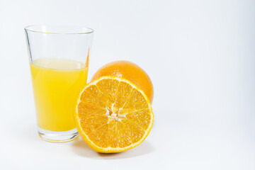 Perfectly retouched sliced orange in the middle. Fresh oranges isolated on white background. Freshly picked oranges. Orange juice. Glass of orange juice. Close up.