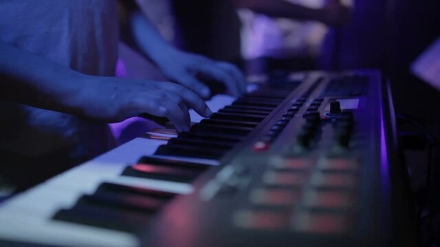 Musician playing on the keyboard synthesizer piano keys. Musician plays a musical instrument on the concert stage