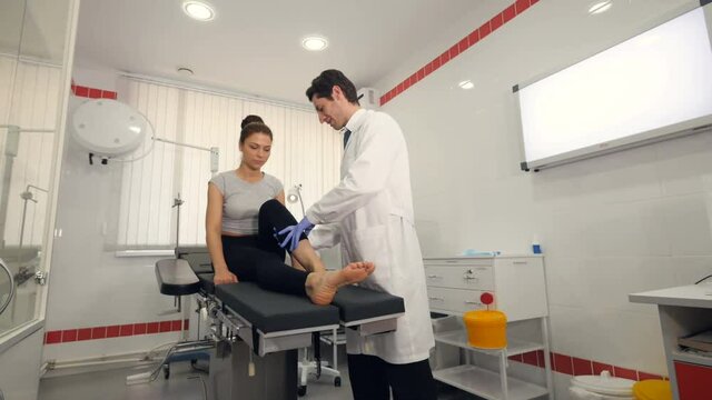 A doctor examines the girl's ankle at a hospital