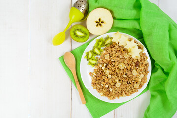 Granola for breakfast with fresh kiwi and apple