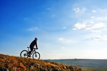 Obraz premium Cyclist on the Beautiful Meadow Trail on sunny day
