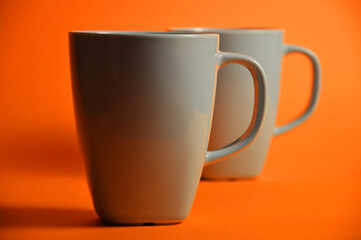 Coffee Mugs on orange surface with space