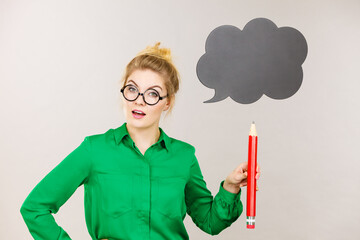 Woman holding big oversized pencil thinking