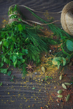 Mix of fresh herbs and spices assortment on wooden background.