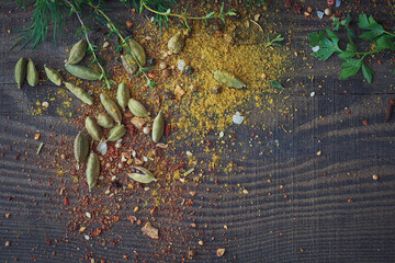 Mix of fresh herbs and spices assortment on wooden background.
