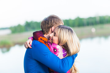 Portrait of beautiful young couple in love embracing near the lake.