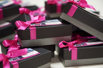 Black and grey giveaway boxes with ribbons - obrazy, fototapety, plakaty