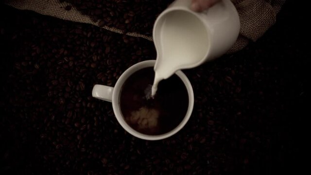 Pouring milk in coffee in slow motion